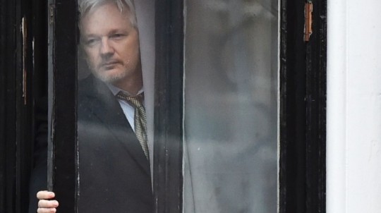 WikiLeaks founder Julian Assange steps out on the balcony of the Ecuadoran Embassy to address the media in London in February. (Ben Stansall/AFP via Getty Images)