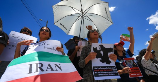 Una de las manifestantes portaba la foto de Amini con la leyenda "Todos somos Mahsa Amini" y la bandera de Irán / Foto: EFE