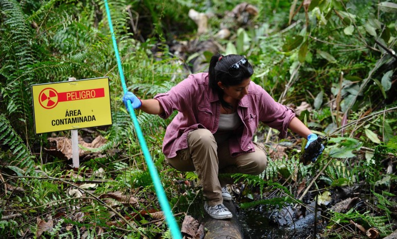 Una mujer muestra una botella con petróleo, en una imagen de 2013 en Aguarico, en la región amazónica de Ecuador. Foto: El País