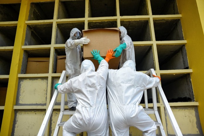 Trabajadores llevan un ataúd de cartón con el cuerpo de una persona que, se cree, murió de la COVID-19 durante un funeral esta semana en Daule, Ecuador.Credit...Mauricio Torres/EPA vía Shutterstock