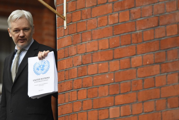 WikiLeaks founder Julian Assange holds a copy of a UN ruling as he makes a speech from the balcony of the Ecuadorian Embassy, in London, February 5, 2016.