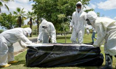 Trabajadores del cementerio Parque de la Paz enterraban a un fallecido este lunes, en el norte de Guayaquil. Foto: Mauricio Torres / EFE