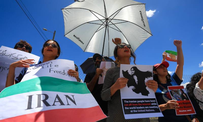 Una de las manifestantes portaba la foto de Amini con la leyenda "Todos somos Mahsa Amini" y la bandera de Irán / Foto: EFE